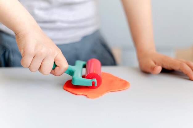 Close-up boy playing with plasticine