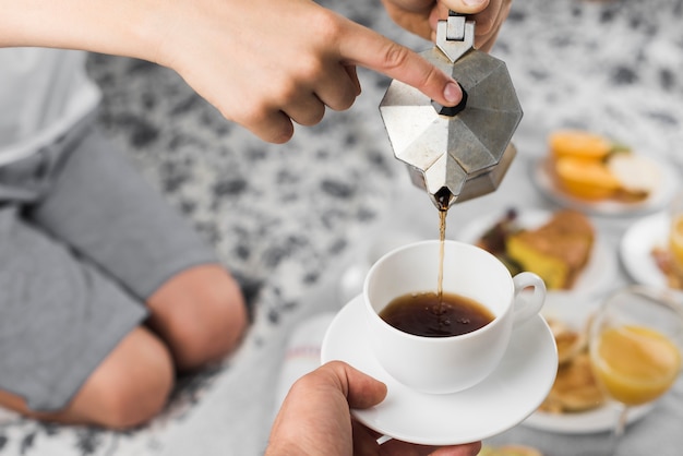 一杯のブラックコーヒーを注いで少年のクローズアップ