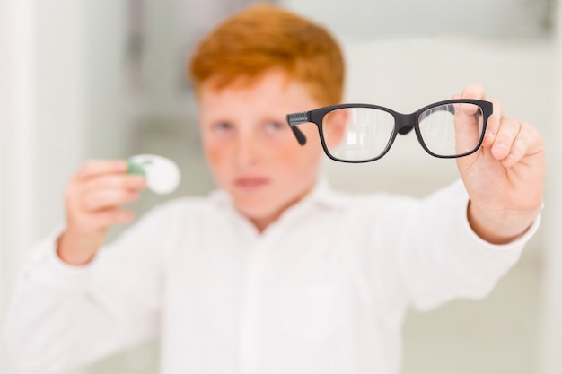 Close-up of boy showing black frame eyeglasses