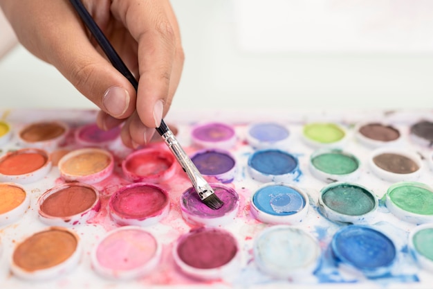 Free photo close-up boy using aquarelle at home