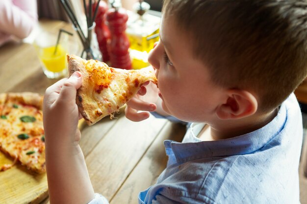 Close up boy with pizza slice