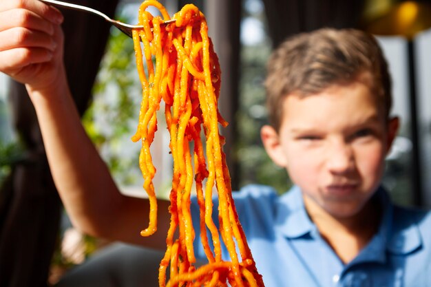 スパゲッティで男の子をクローズアップ