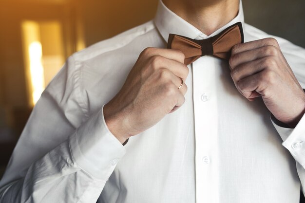 Close-up of a boyfriend arranging his bow tie