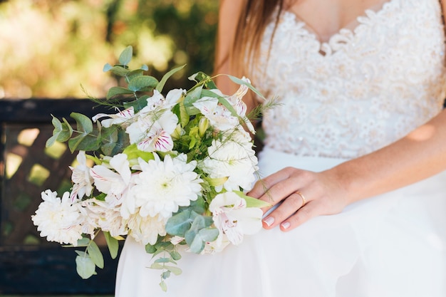 Close-up of bride holding flower bouquet in hand