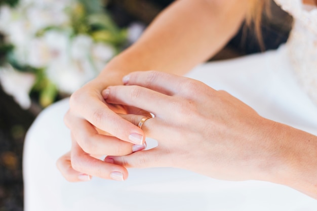Крупный план руки невесты, касающейся ее обручального кольца на пальце