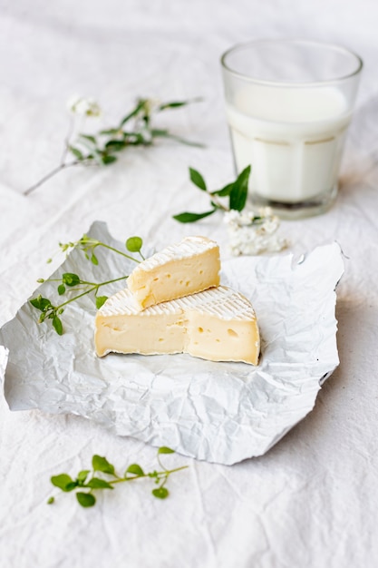 Foto gratuita brie del primo piano con un bicchiere di latte