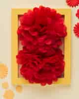 Foto gratuita close-up del fiore di carta rosso brillante e cornice per foto
