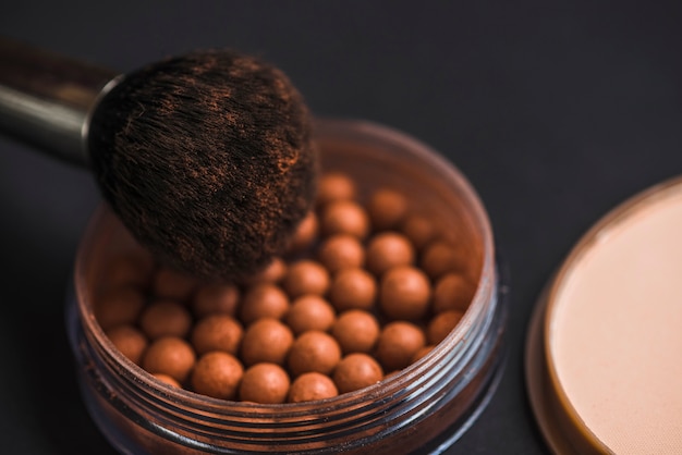 Close-up of bronzing pearls and makeup brush