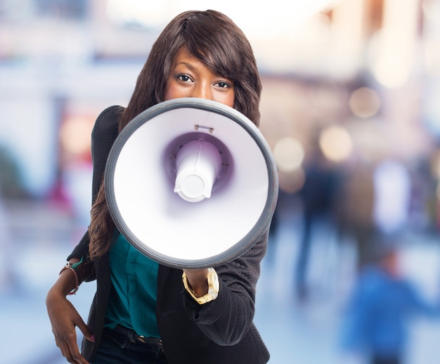 Close-up of brunette girl playing with a megaphone