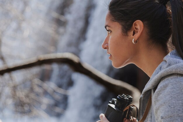 Foto gratuita close-up della ragazza bruna con il binocolo