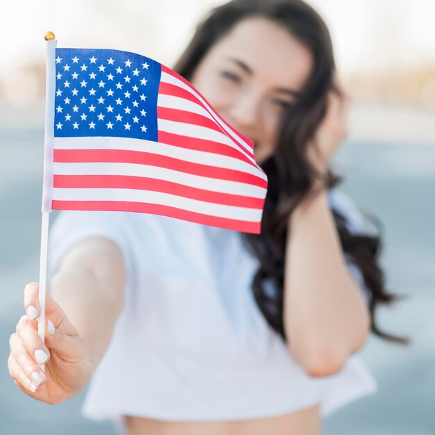 Крупным планом брюнетка женщина держит флаг США