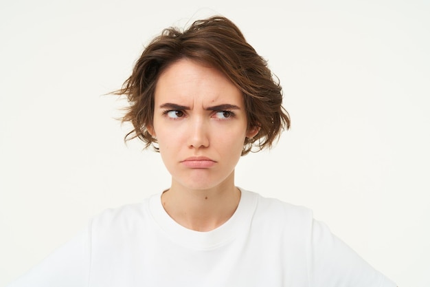 Free photo close up of brunette woman shows angry face frowning grumpy pouting and looking disappointed