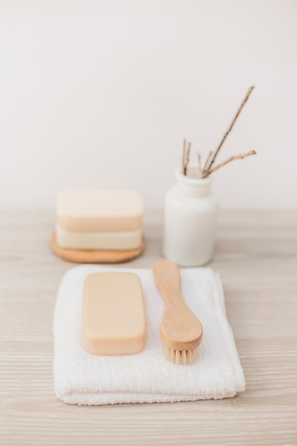 Close-up of brush; soap and towel on wooden surface