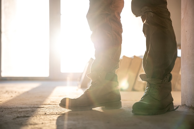 Close-up of a builder in work clothes and boots, close-up, part of the body.