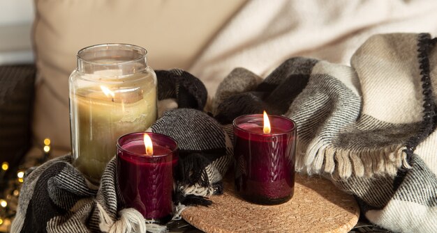 Close up of burning candles in candlesticks with details of home comfort.