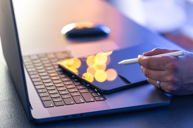 Бесплатное фото Близкая деловая рука со стилусом и ручкой, работающая на цифровом планшете и ноутбуке