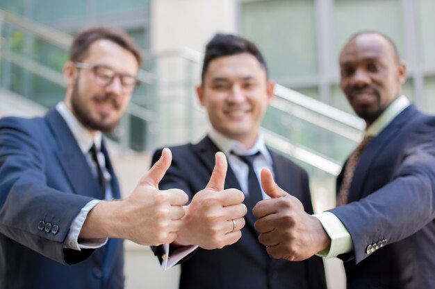 Close-up of business team holding their thumbs up