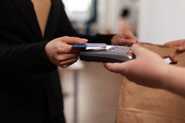 Close up of business woman holding credit card of pos