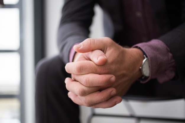 Close-up of businessman hands sitting on chair