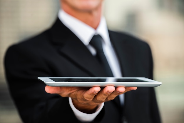 Close-up businessman holding tablet in hand