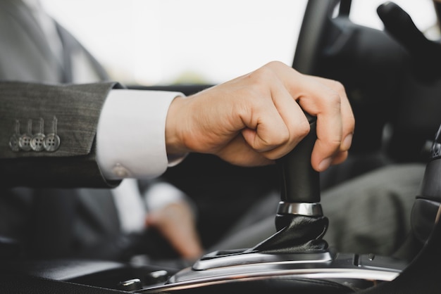 Close-up of businessman's hand gripping the gear in car