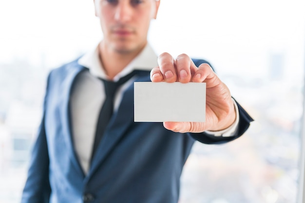 Close-up of businessman's hand showing blank business card