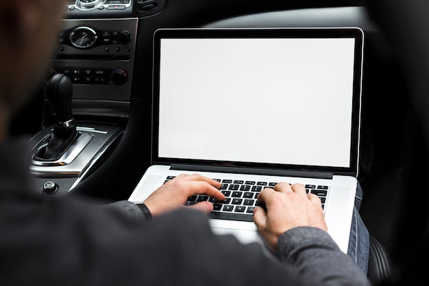 Крупный план руки бизнесмена с помощью ноутбука, сидя в машине