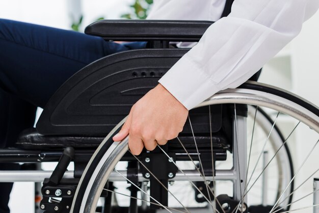 Free photo close-up of a businessman's hand on wheel of wheelchair