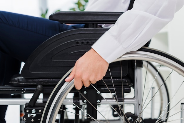 Крупный план руки бизнесмена на инвалидной коляске