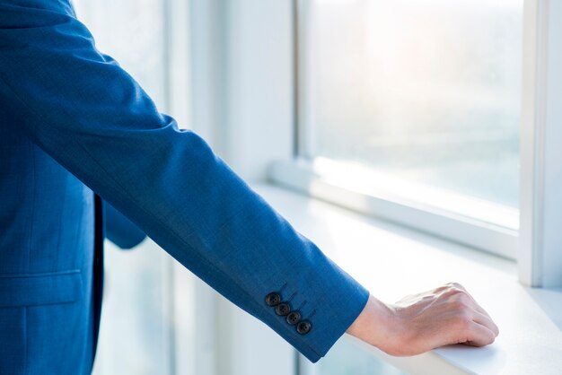 Close-up of a businessman's hand on windowsill