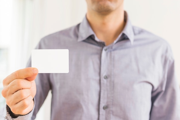 Close-up of businessman showing blank white visiting card