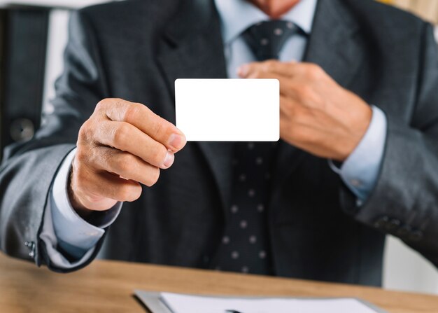 Close-up of businessman showing blank white visiting card