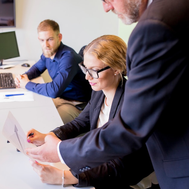 Close-up of businessman showing business report to female colleague