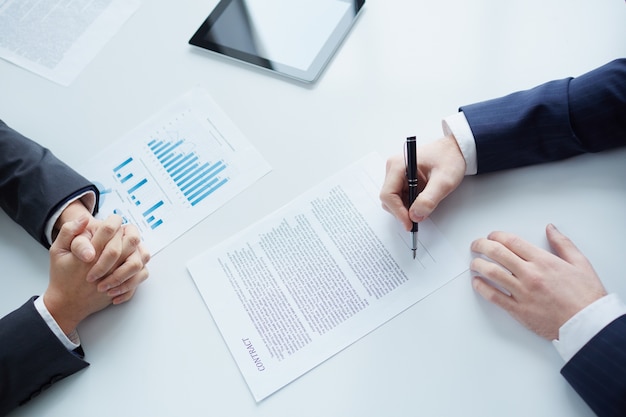 Close-up of businessman sitting and signing a contract