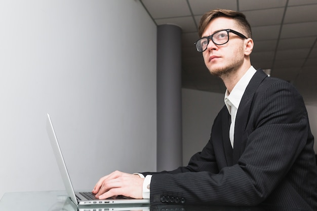 Foto gratuita primo piano di un uomo d'affari con laptop sul posto di lavoro