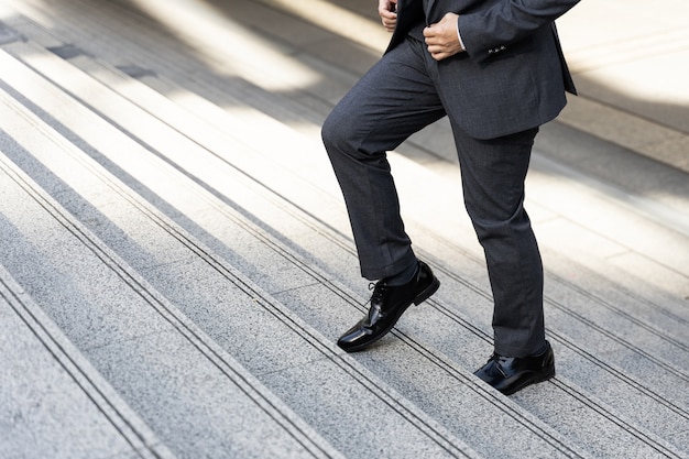 Free photo close up businessman walking stepping up on business district urban, business concept