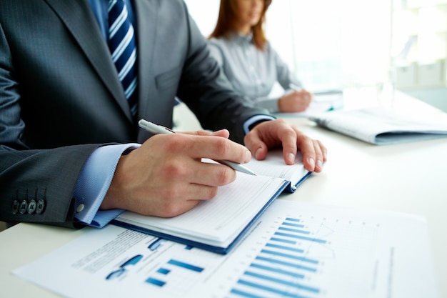 Free photo close-up of businessman writing in a meeting