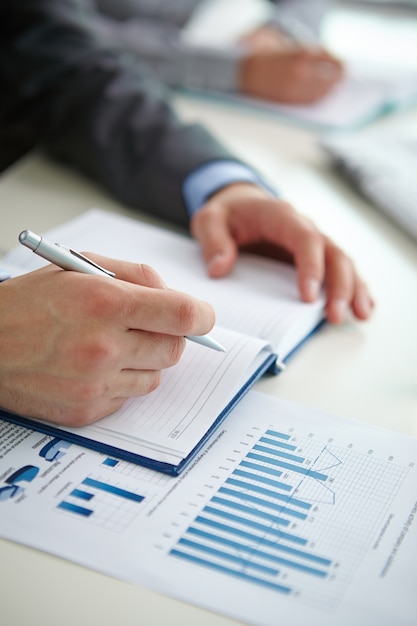 Close-up of businessman writing a summary