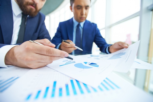 Close-up businessmen working together with diagrams 