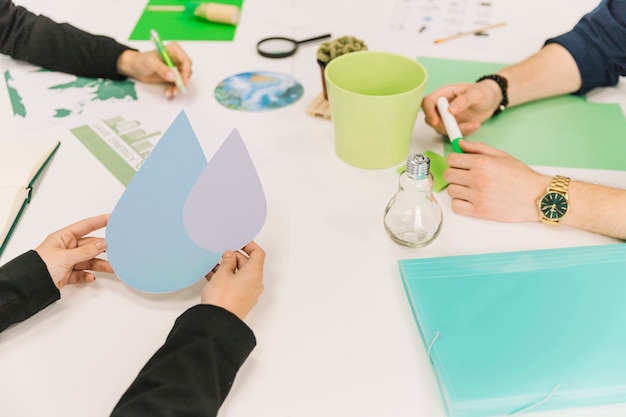 Free photo close-up of a businessperson's hand holding water drop symbol