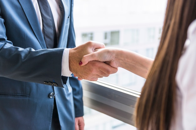 Close-up of businesswoman and businessman shaking hands