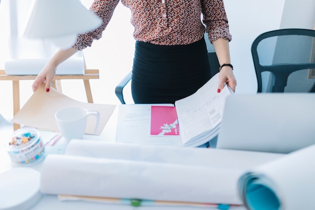 Close-up of a businesswoman holding an opened file on desk