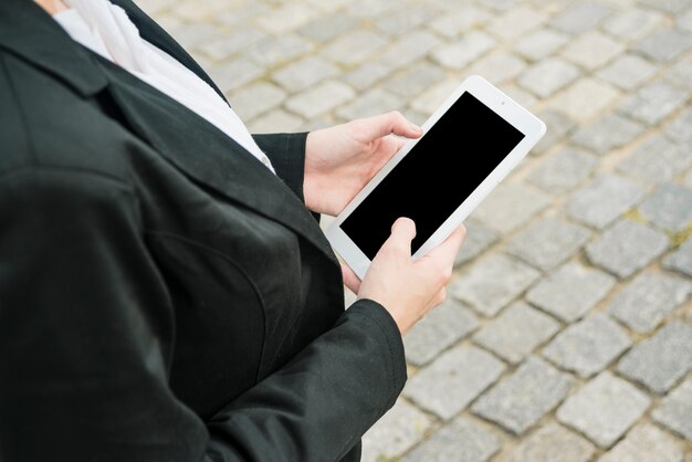 Close-up of a businesswoman's hand using blank mobile phone at outdoors