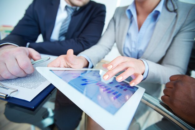 Close-up of businesswoman showing graph on digital tablet