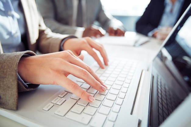 Close-up of businesswoman typing on computer keyboard