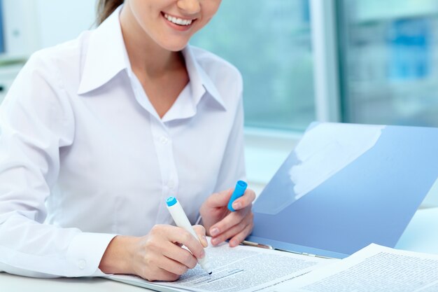 Close-up of businesswoman underlining a report