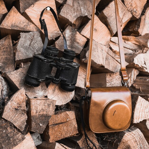 Close-up camera and binoculars on firewood