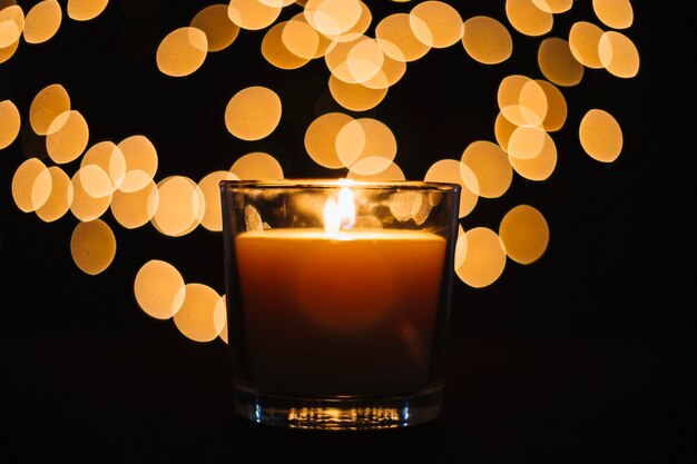 Close-up candle near blurred lights