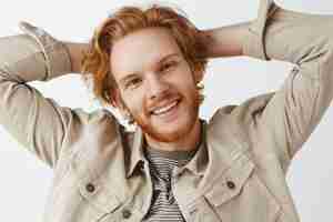 Free photo close-up of carefree bearded redhead guy posing against the white wall