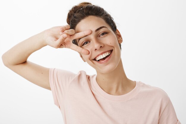 Close-up of carefree girl posing against the white wall